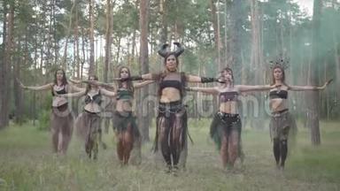 穿着森林居民或魔鬼的戏剧服装的年轻妇女在迷人的森林中表现出芬芳和<strong>跳舞</strong>的肚皮